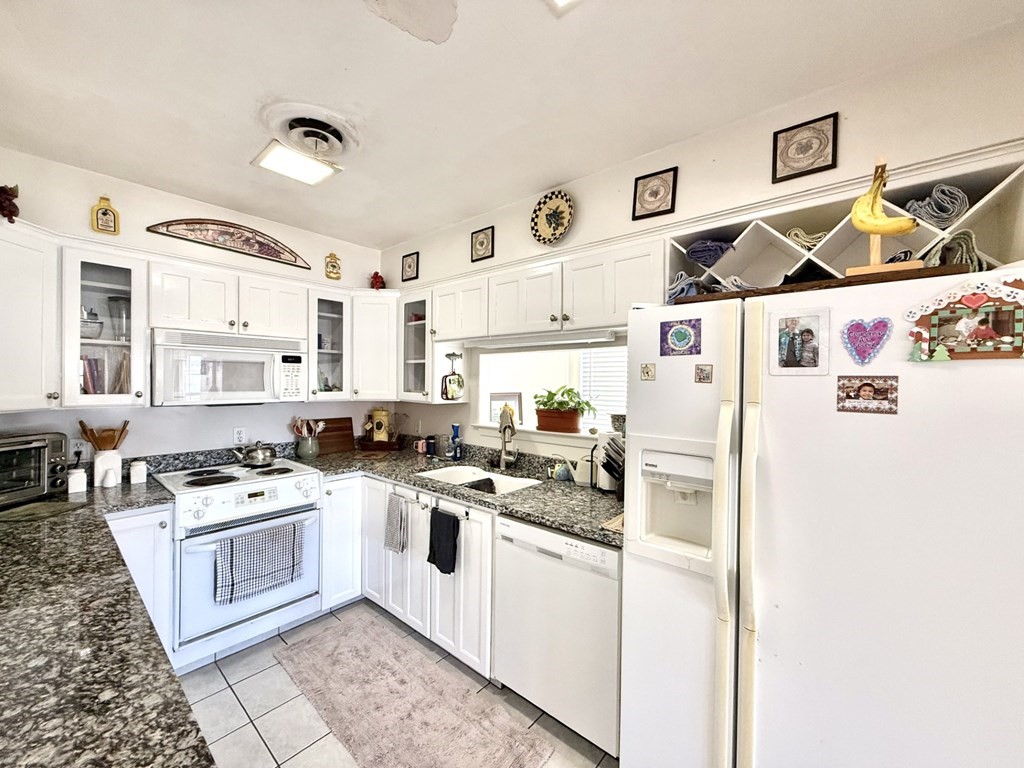 30 Flamingo Road Rockport, TX 78382 - Photo 18 of 39 a white kitchen with stainless steel appliances granite countertop a stove and a refrigerator