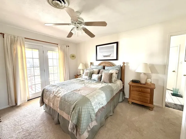 a spacious bedroom with a bed and ceiling fan