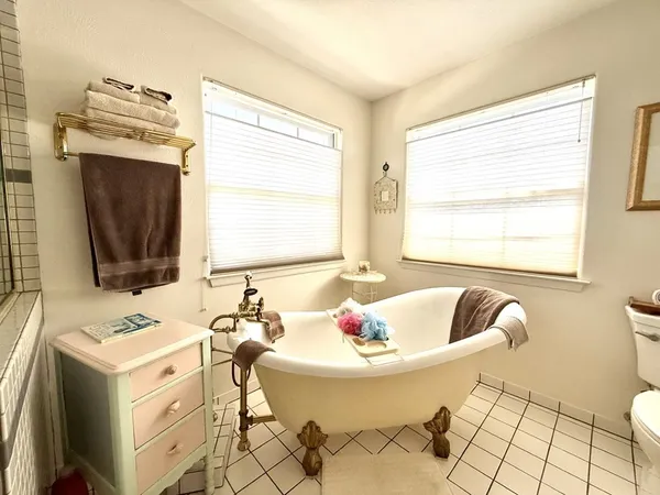 a bathroom with a tub sink and mirror