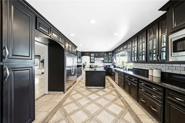 a kitchen with stainless steel appliances a sink stove and cabinets