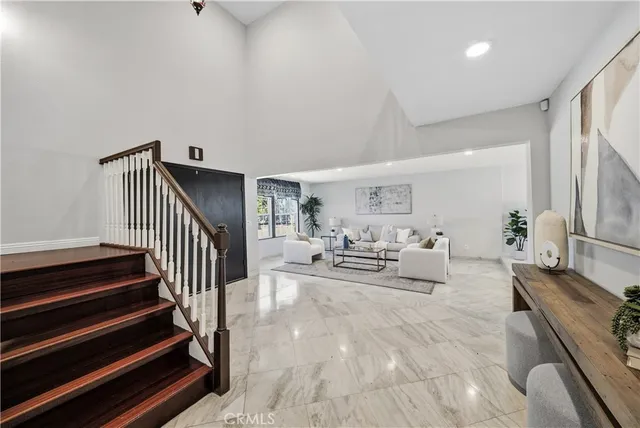 a furnished livingroom with a window and wooden floor