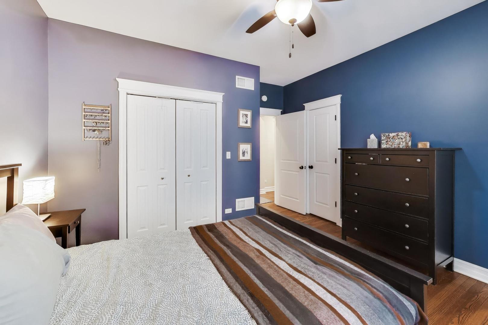 4441 North Beacon Street, Unit 2A Chicago, IL 60640 - Photo 13 of 23 a bedroom with a bed and a chandelier