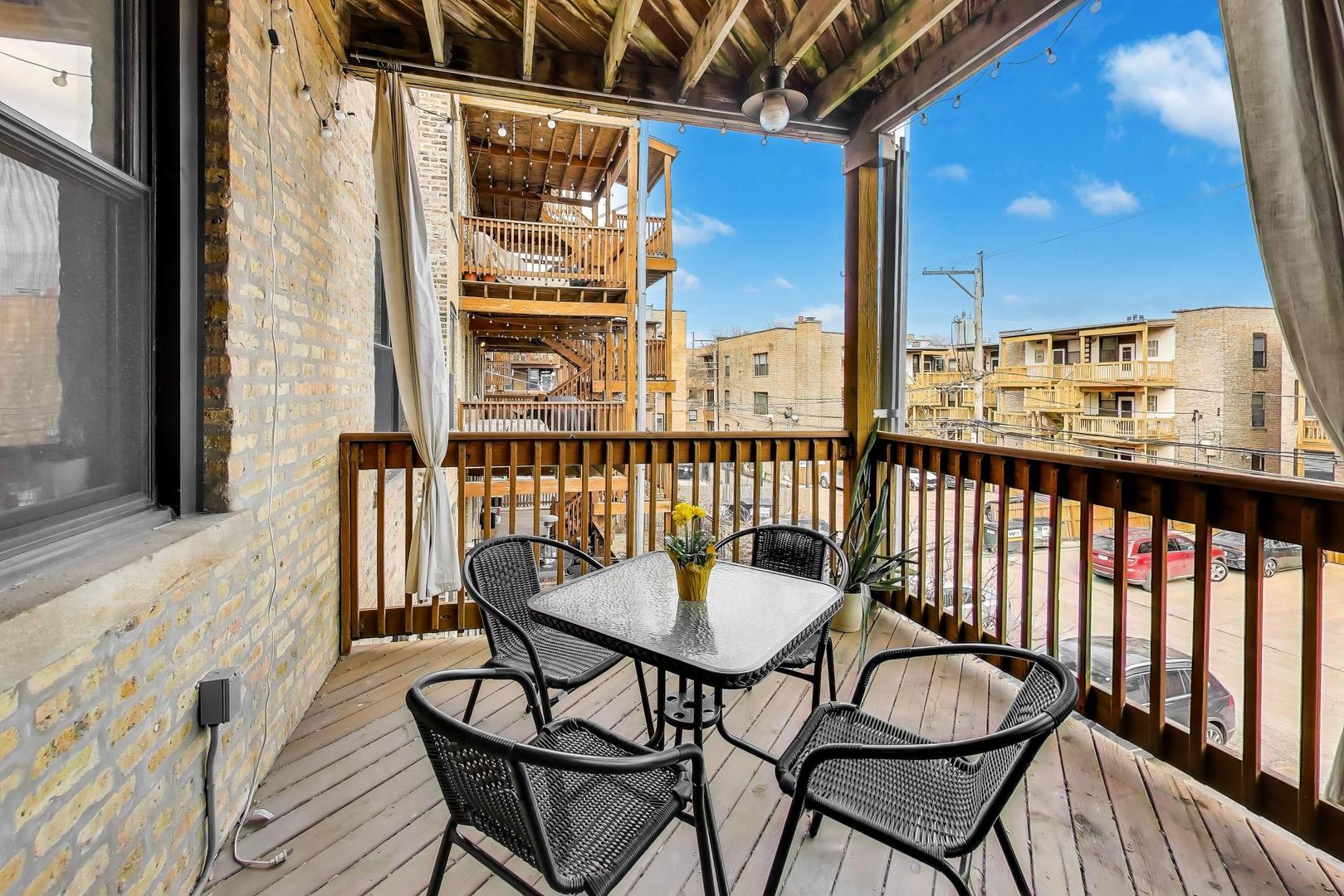 4441 North Beacon Street, Unit 2A Chicago, IL 60640 - Photo 21 of 23 a balcony with table and chairs