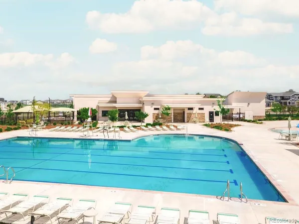 a view of swimming pool from a balcony with outdoor seating