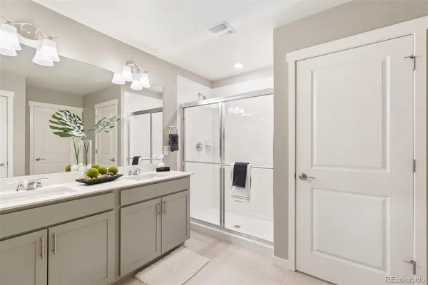 a bathroom with a double vanity sink mirror and shower