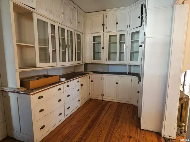 a view of a livingroom with wooden floor and a fireplace
