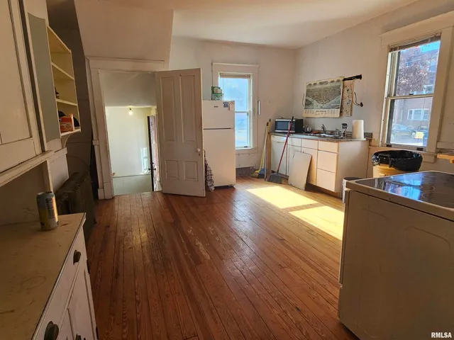 a view of a livingroom with wooden floor and a fireplace