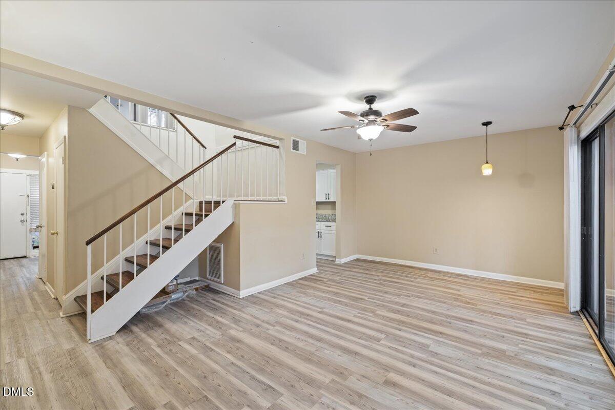 1738 Quail Ridge Road Raleigh, NC 27609 - Photo 19 of 38 a view of an empty room with wooden floor and a ceiling fan
