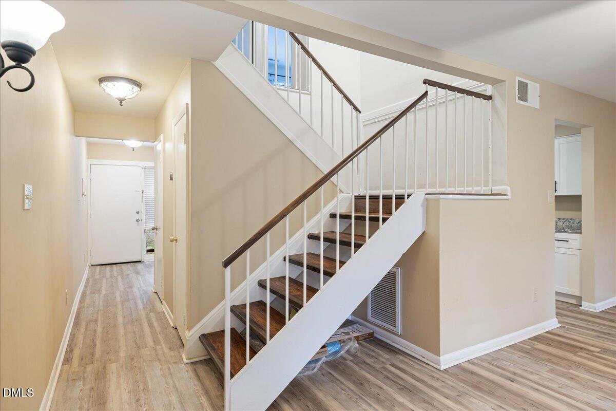 1738 Quail Ridge Road Raleigh, NC 27609 - Photo 20 of 38 a view of staircase with wooden floor and white walls