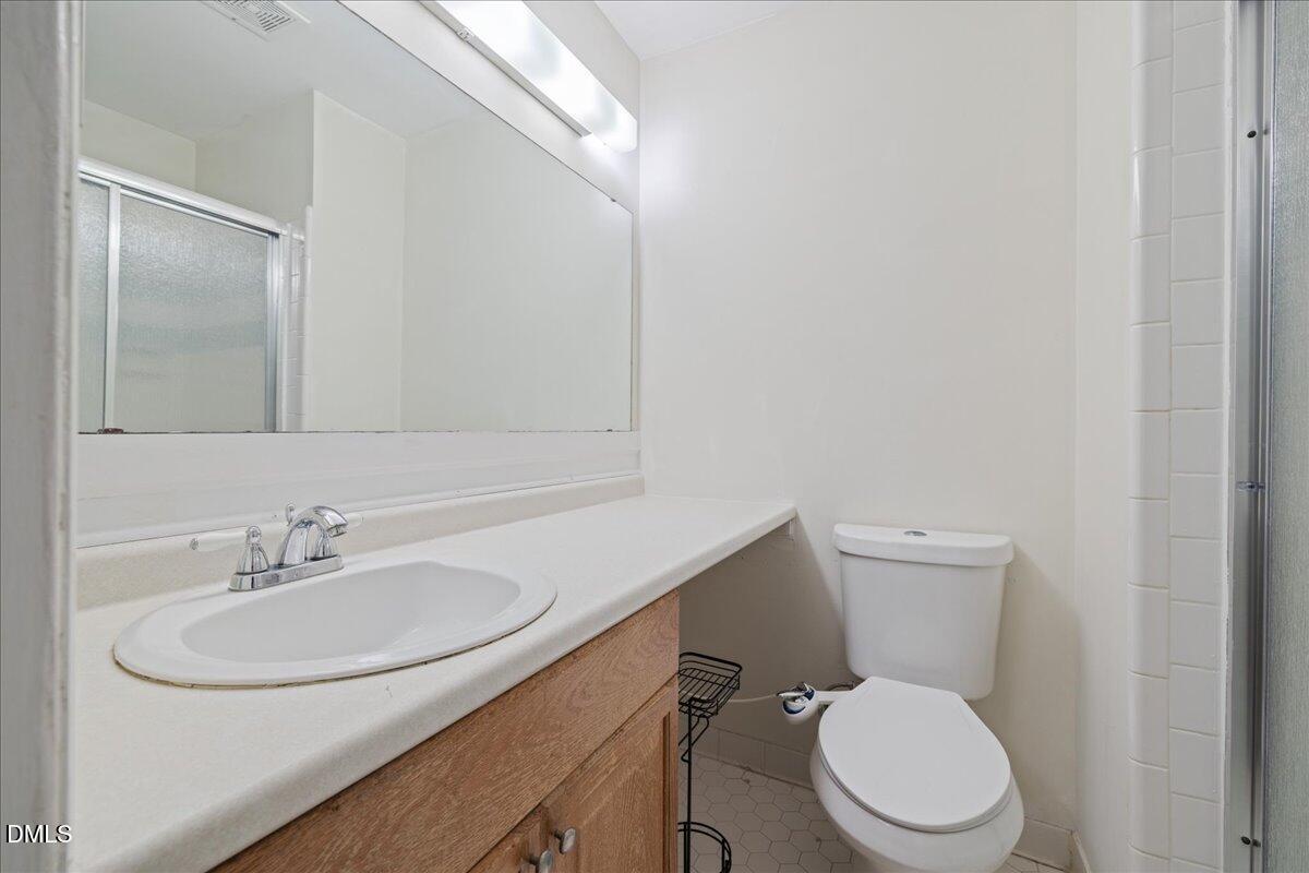 1738 Quail Ridge Road Raleigh, NC 27609 - Photo 28 of 38 a bathroom with a toilet a sink and mirror