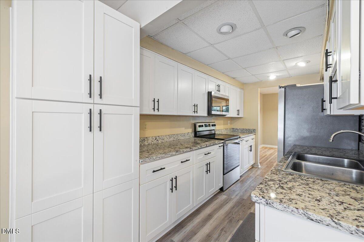 1738 Quail Ridge Road Raleigh, NC 27609 - Photo 8 of 38 a kitchen with granite countertop a sink stove and refrigerator