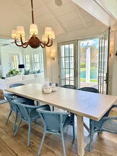 a kitchen with stainless steel appliances a stove a sink a oven a dining table and chairs