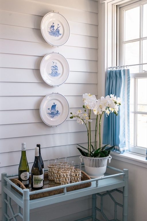 106 A Surfside Road, Unit EAST Nantucket, MA 02554 - Photo 18 of 42 a table with a vase and flowers on it