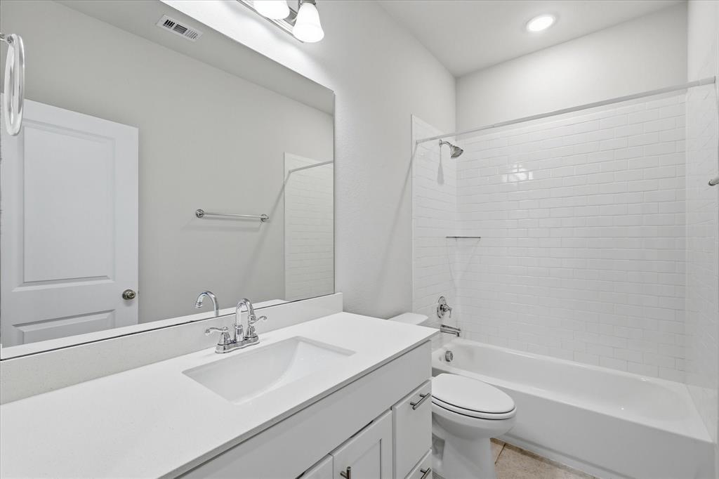 519 Sequoia Street Allen, TX 75002 - Photo 31 of 38 Bathroom featuring a white subway tile shower, white vanity with integrated sink, chrome fixtures, and a large wall-mounted mirror