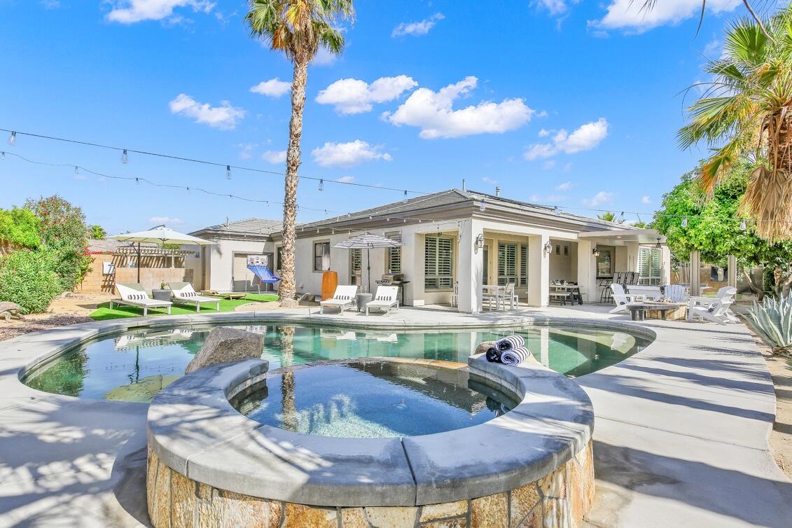 48713 Spring Rain Court Indio, CA 92201 - Photo 17 of 66 a living room with fireplace furniture and a chandelier