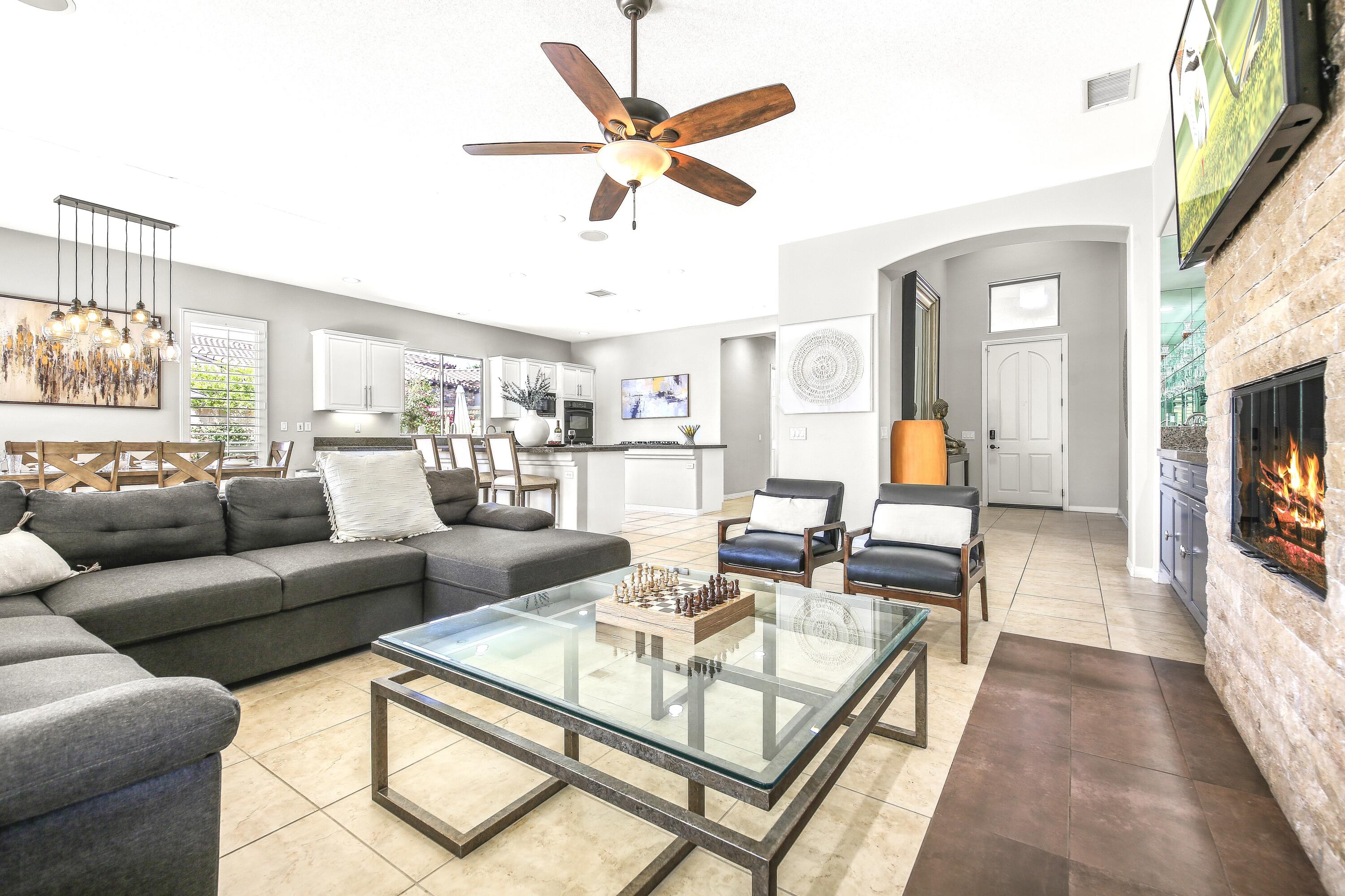 48713 Spring Rain Court Indio, CA 92201 - Photo 21 of 66 a living room with furniture a fireplace and a large window