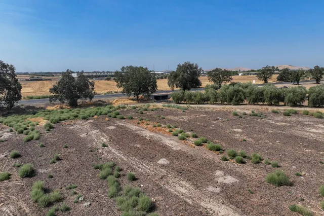 a view of a dirt road with a building in the background