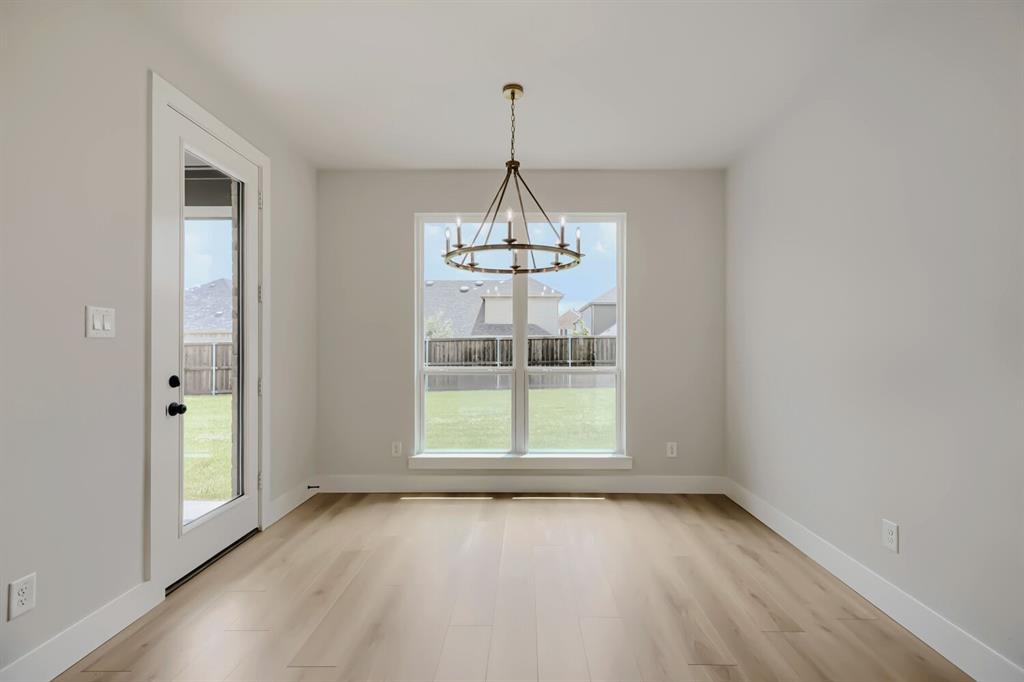 4414 Windy Point Road Oak Point, TX 75068 - Photo 18 of 27 a view of an empty room with wooden floor and a window