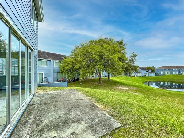 a view of a house with a big yard plants and large trees