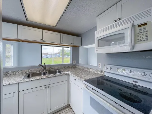 a kitchen with stainless steel appliances granite countertop a sink and a stove