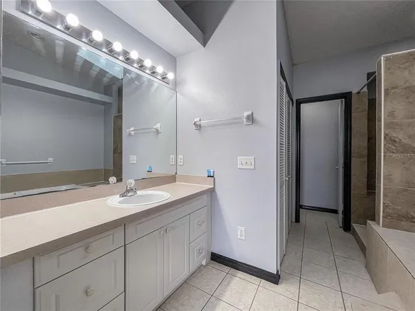 a spacious bathroom with a granite countertop sink a mirror and a shower
