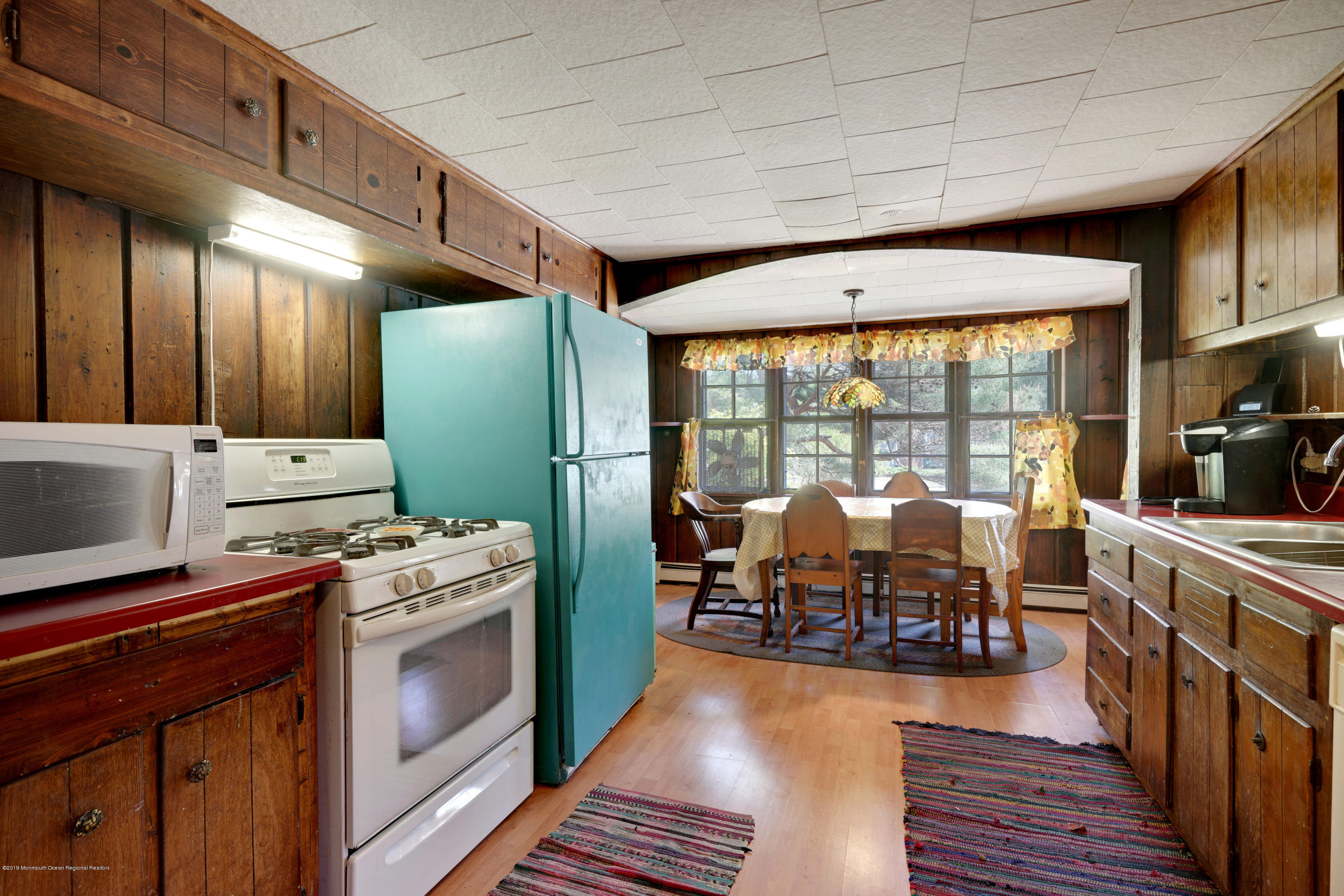 100 Breton Road Brick, NJ 08723 - Photo 26 of 37 a open kitchen with stainless steel appliances granite countertop a stove top oven a dining table and chairs with wooden floor