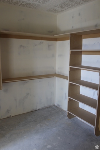 4933 East Remington Road Cedar City, UT 84721 - Photo 23 of 33 Interior space featuring unfinished concrete flooring, walls prepped for finishing, and a built-in shelving unit