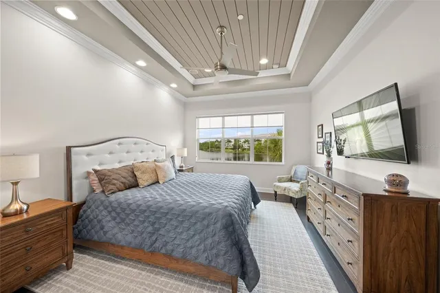 a bedroom with a large bed and a flat tv screen on dresser