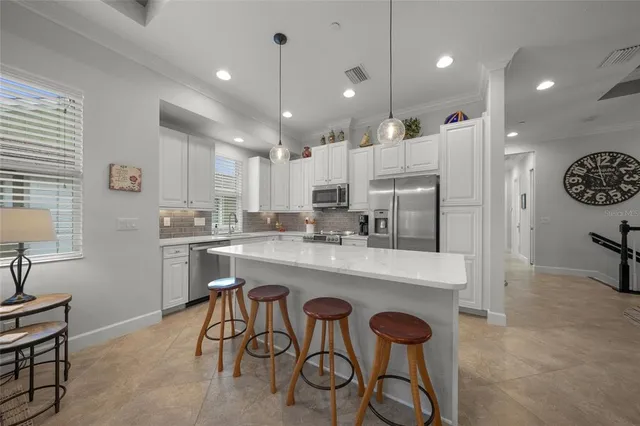 a kitchen with stainless steel appliances granite countertop a sink and a refrigerator