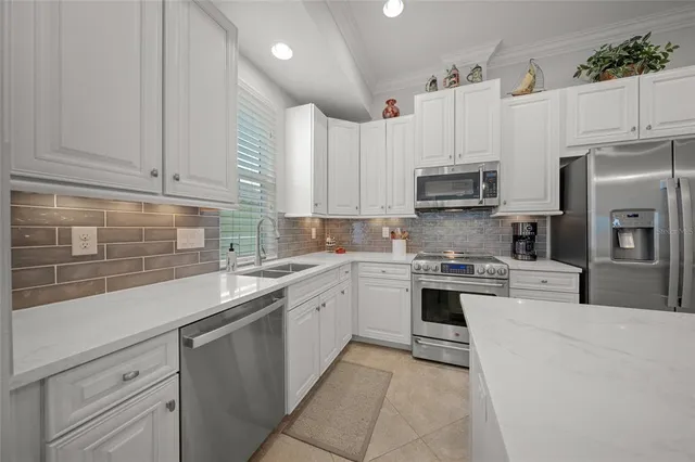 a kitchen with kitchen island granite countertop white cabinets and white stainless steel appliances