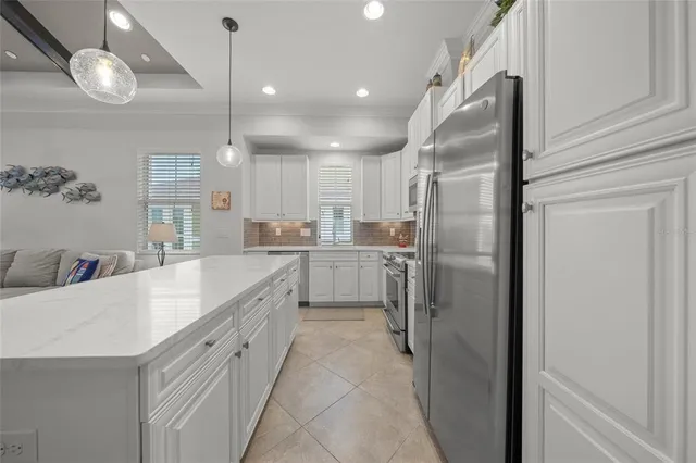 a large kitchen with a refrigerator a sink and cabinets