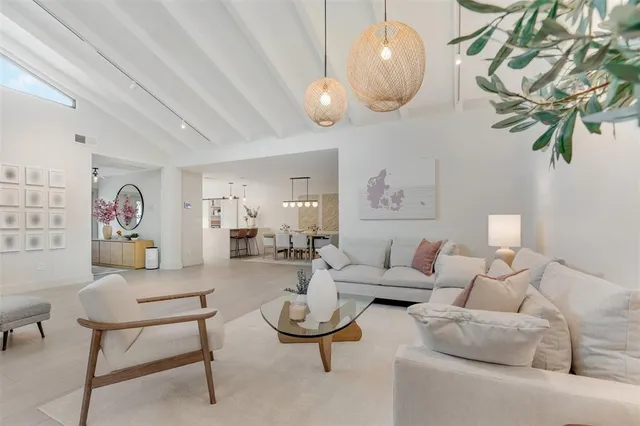 a living room with furniture a rug and a mirror