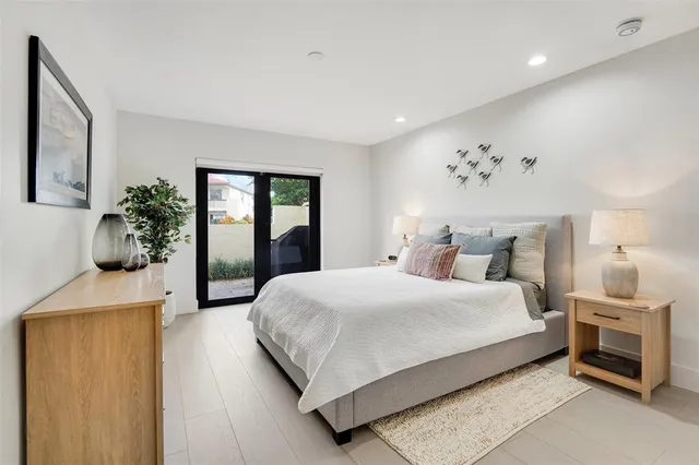 a bedroom with a large bed and a potted plant