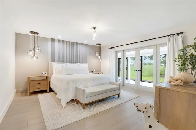 a spacious bedroom with a bed and glass walk in closet