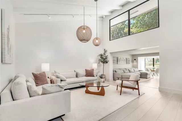 a living room with furniture a rug and a large window