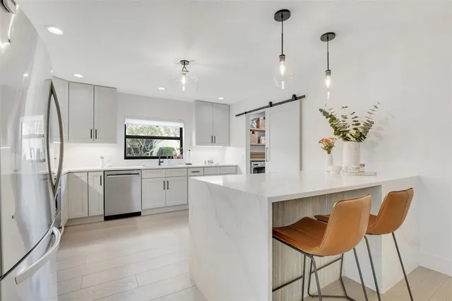 a kitchen with white cabinets and stainless steel appliances
