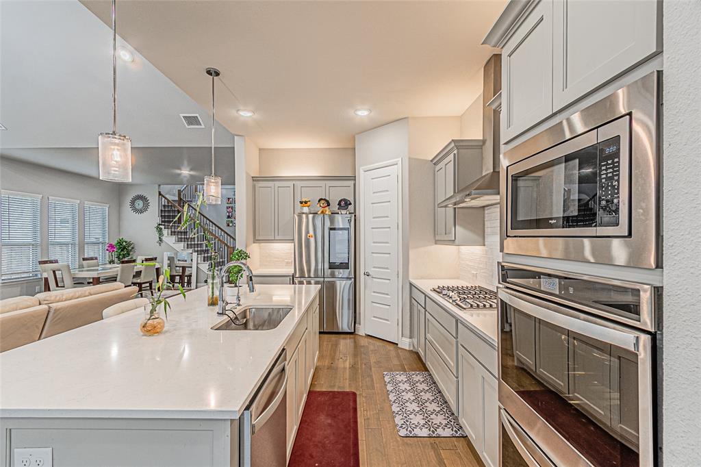 13261 Jonata Street Frisco, TX 75035 - Photo 14 of 40 a kitchen with stainless steel appliances kitchen island granite countertop a sink and dishwasher a oven with wooden cabinets