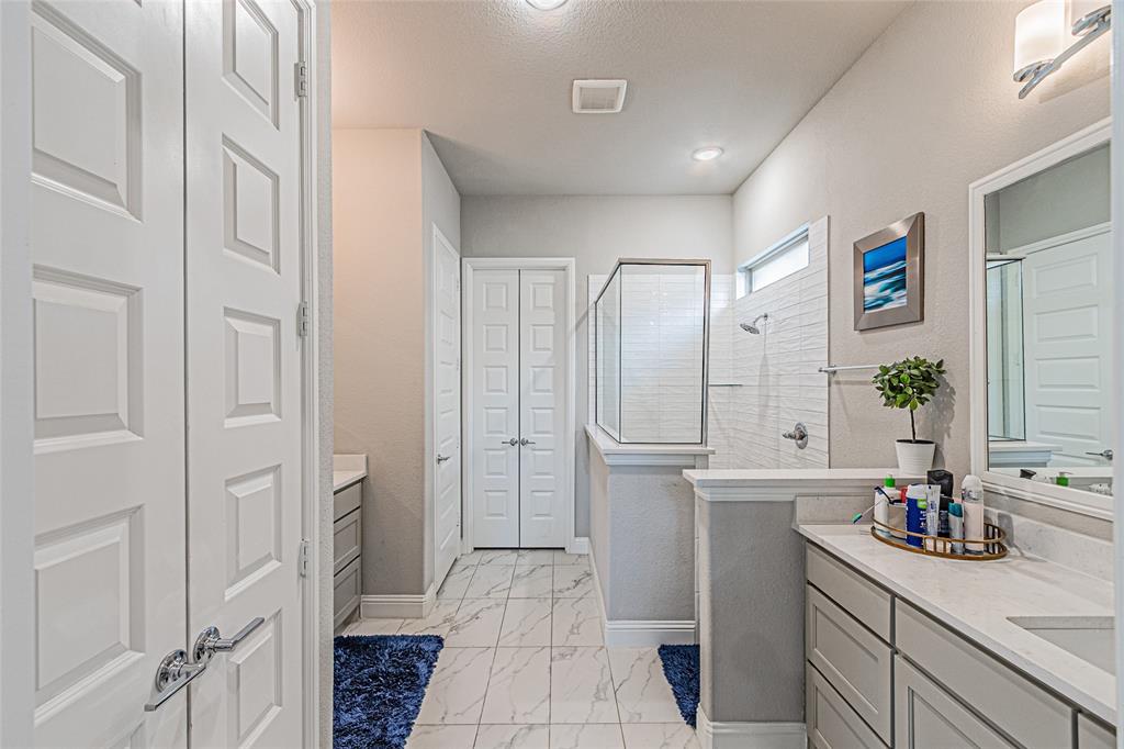 13261 Jonata Street Frisco, TX 75035 - Photo 21 of 40 a spacious bathroom with a granite countertop sink a mirror and a shower