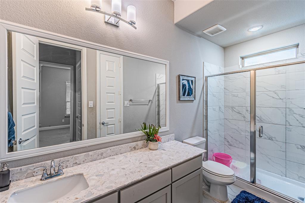 13261 Jonata Street Frisco, TX 75035 - Photo 23 of 40 a bathroom with a granite countertop sink a toilet and shower