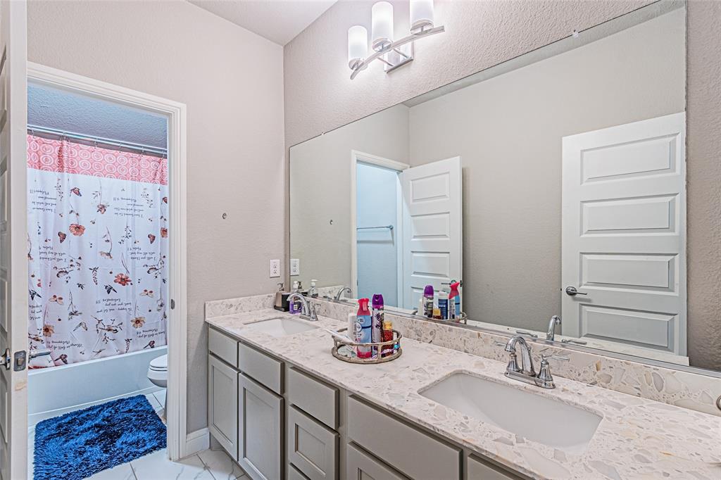 13261 Jonata Street Frisco, TX 75035 - Photo 33 of 40 a bathroom with a granite countertop sink a toilet a mirror and shower
