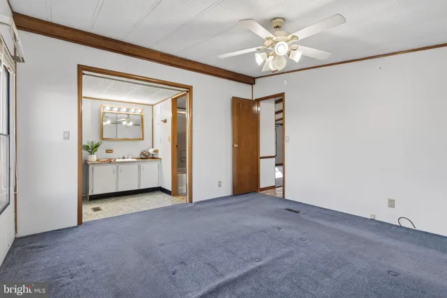 an empty room with windows closet and chandelier fan