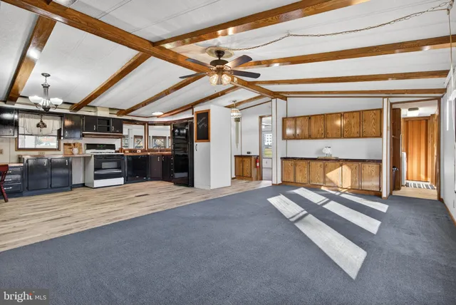 a kitchen with stainless steel appliances kitchen island granite countertop a refrigerator a sink dishwasher a stove and a refrigerator with wooden floor