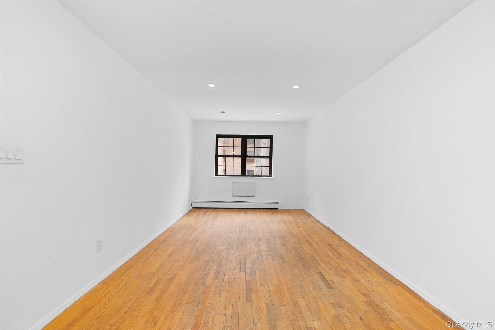 84-30 98th Street Queens, NY 11421 - Photo 12 of 35 an empty room with wooden floor and windows