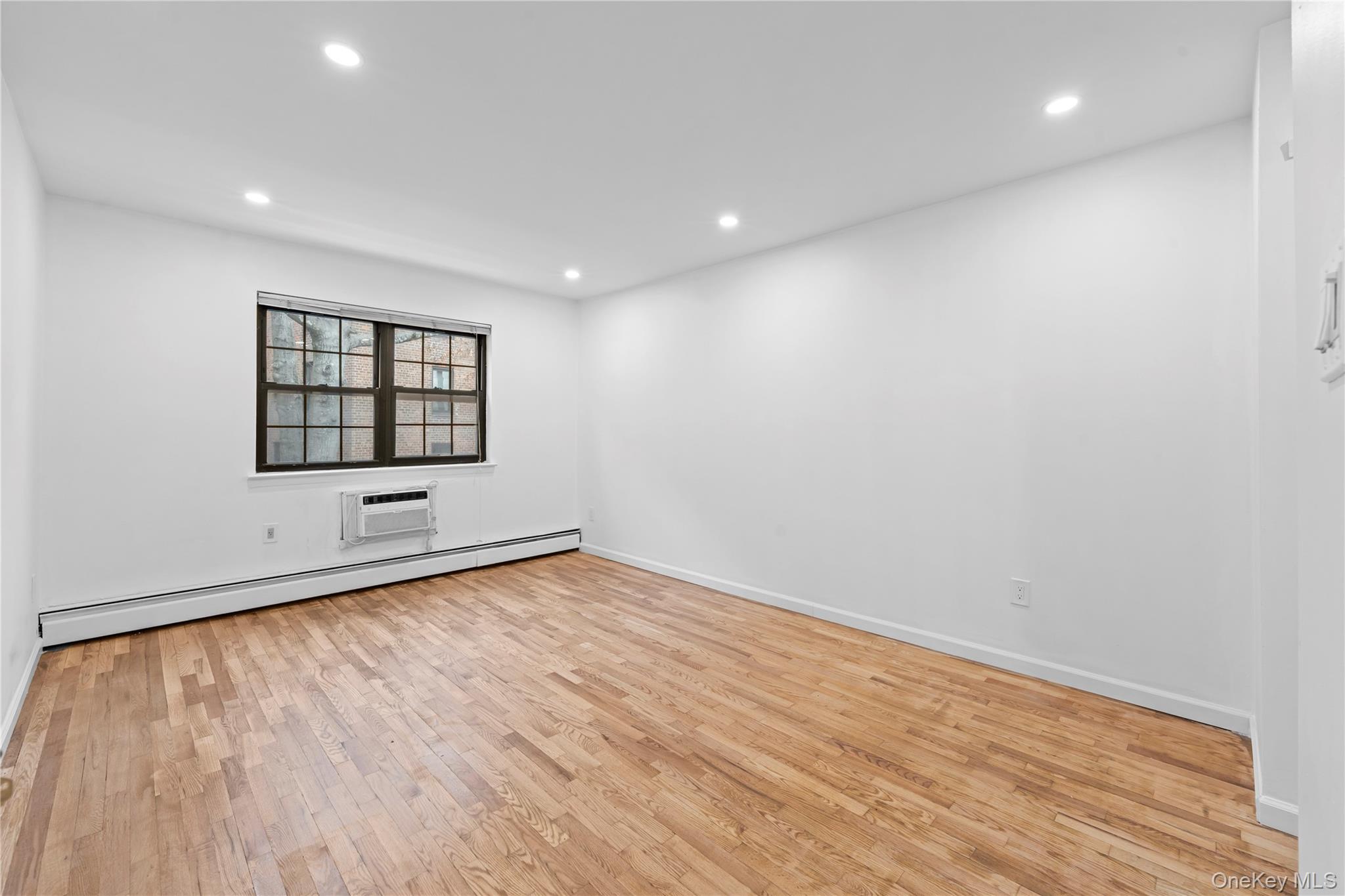 84-30 98th Street Queens, NY 11421 - Photo 14 of 35 an empty room with wooden floor and windows