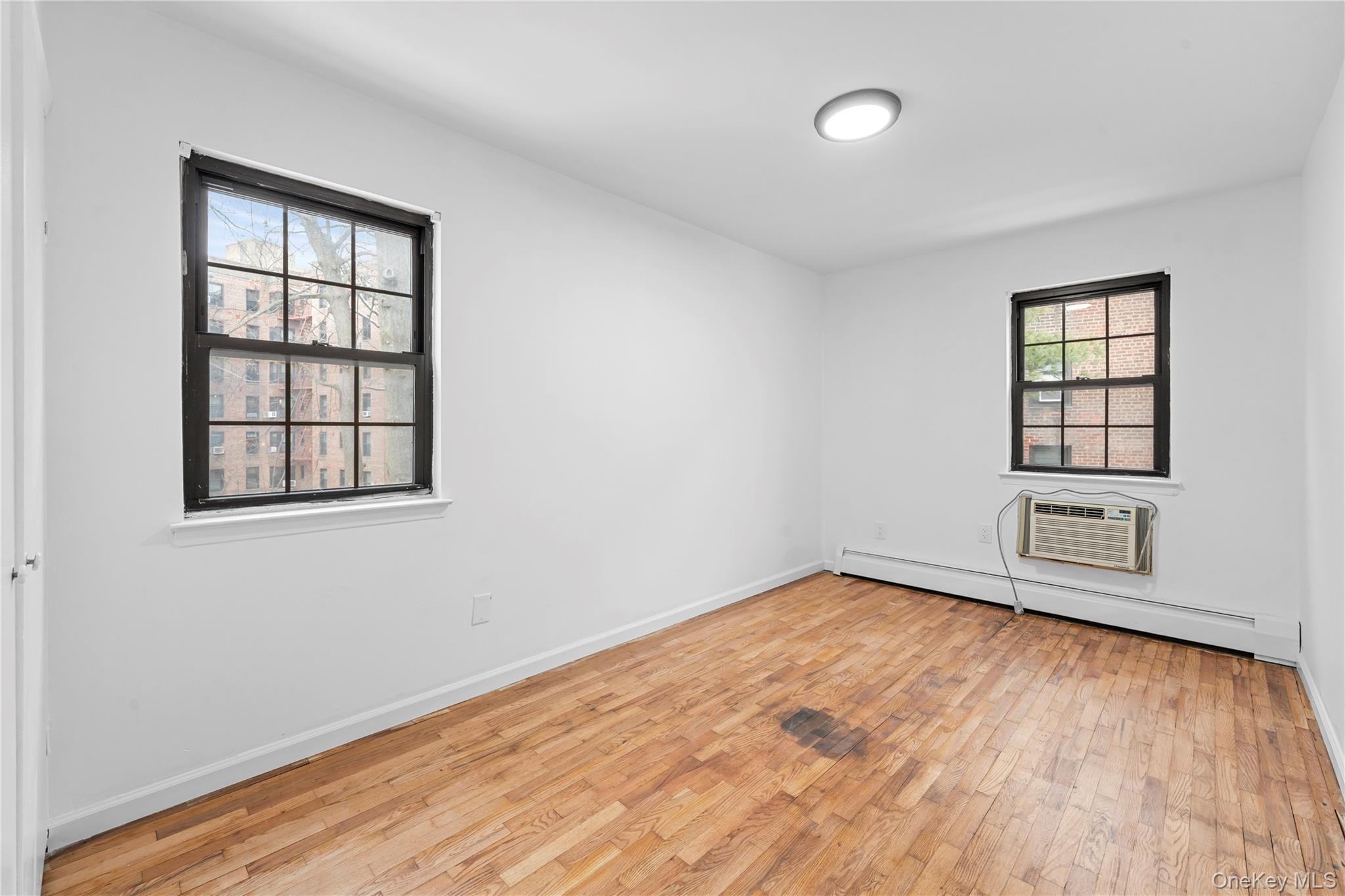 84-30 98th Street Queens, NY 11421 - Photo 16 of 35 an empty room with wooden floor and windows
