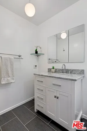 a bathroom with a granite countertop sink and a mirror