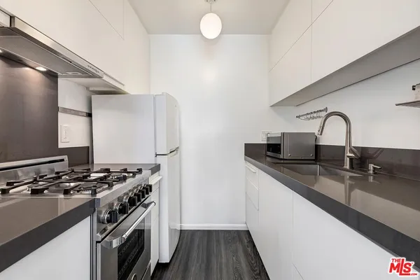 a kitchen with stainless steel appliances a sink stove and cabinets