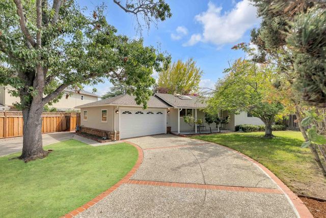 a view of house with a big yard and large trees