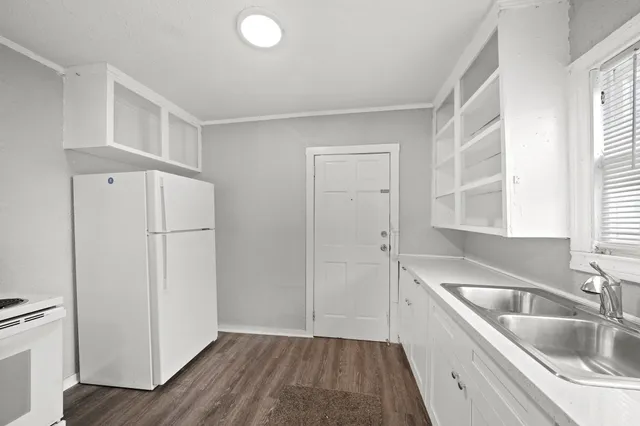 a kitchen with a refrigerator sink and cabinets