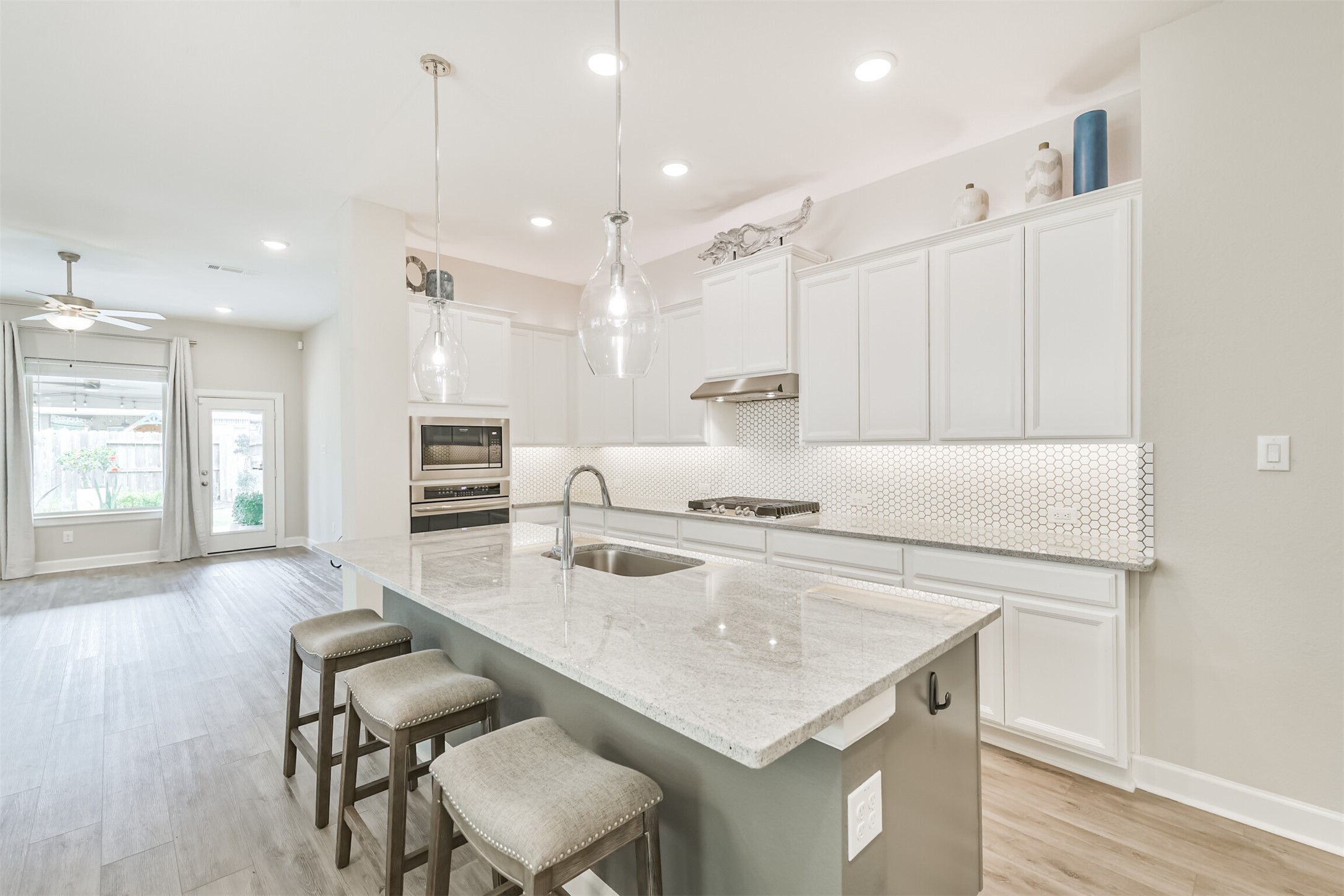 15611 Rising Wren Court Conroe, TX 77302 - Photo 15 of 38 a kitchen with kitchen island a stove a table and chairs in it